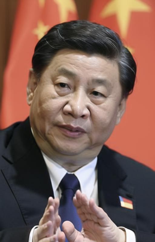 A Chinese man wearing a suit and tie, with his hands in front of him.